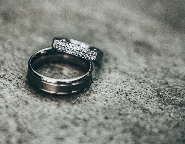 A pair of wedding rings on a grey table